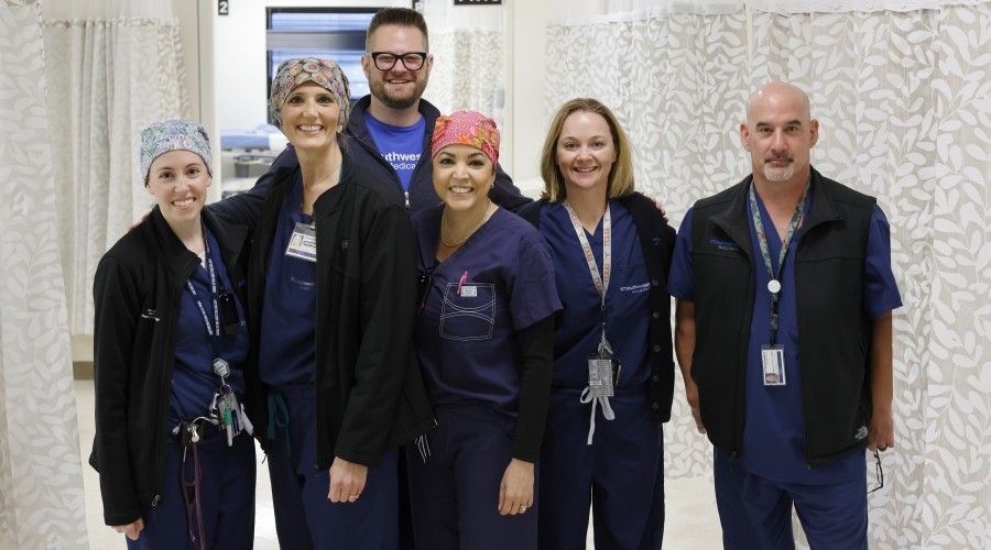 group of 6 APPs in blue UTSW scrubs smile during their day at the hospital