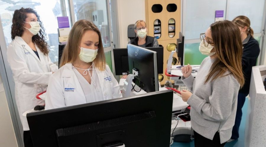 5 medical workers wearing paper masks work on computers in the office