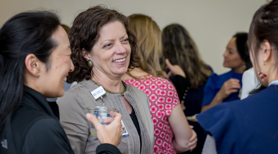 Laura Kirk and others smiling and talking at APP Week celebration 2024