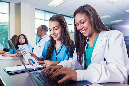 Young female adult college students are studying medicine in healthcare classroom