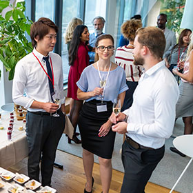 People talking at an event while eating food