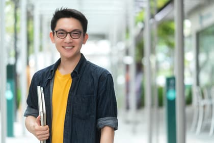 student with a book under his arm