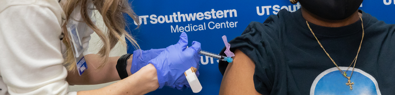 A female nurse gives a man his COVID-19 vaccine in his right arm