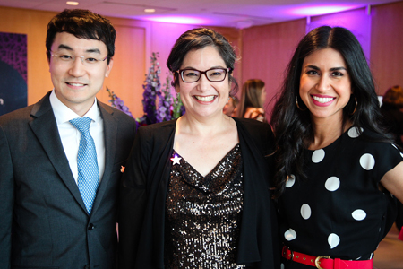 A man wearing a suit and tie, taking a photo with two other women at The Cary Council event 