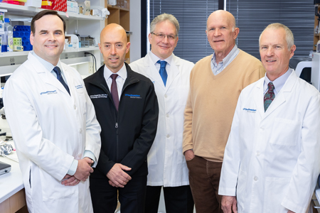 A group of male medical professionals taking photo in lab