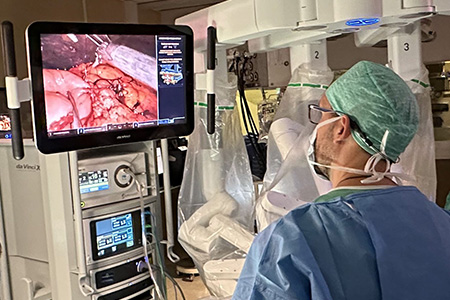 A medical doctor in operating room, wearing a mask and protective clothing