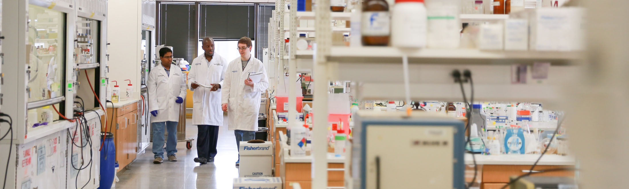 Three male medical professionals collaborating in the lab