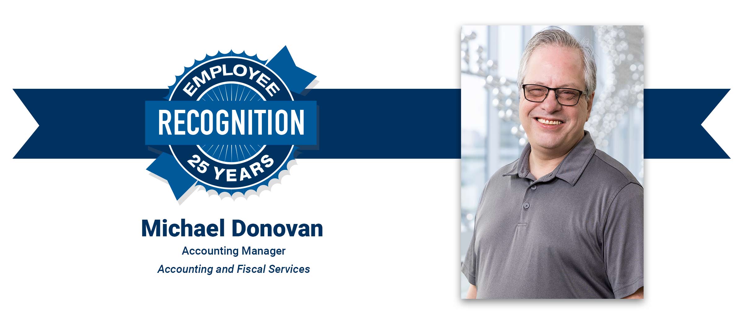 Man with glasses, gray polo shirt, 25 years employee recognition seal