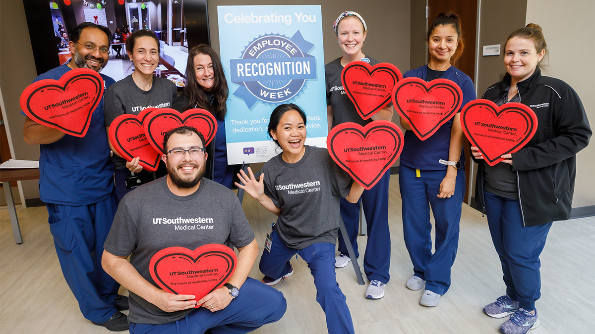 Group photo of employees holding red UT Southwestern hearts celebrating Employee Recognition Week