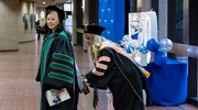 Krystle Campbell, D.H.A., M.S.M.S., CHSE, FACHDM, Assistant Vice President, Education Operations, (right) helps Sherry Huang, M.D., Vice Provost and Senior Associate Dean for Education, with her gown as they prepare for the ceremony.
