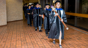 Beth D. Kennard, Psy.D., Professor of Psychiatry, holds the Stembridge Mace that is carried during the academic procession. The symbol represents the torch of learning and passing of knowledge from teacher to student over generations.