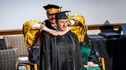 Dean Omer hoods M.P.H. graduate Rick Press, marking his official transition to a public health professional.