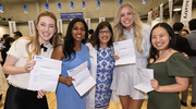 From left: Courtney Koplyay, Meghana Gogineni, Ashley Smith, and Jinghan Zhang show off their match letters to Angela Mihalic, M.D., Dean of Medical Students and Associate Dean for Student Affairs (center).