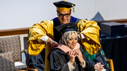 Dean Omer hoods Mai Badran, M.P.H., in a proud academic tradition.