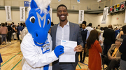 Chijindu Iheanacho celebrates his match with Champ, the Dallas Mavericks mascot.