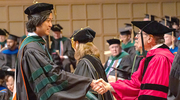 Tung To, M.D., (left) shakes hands with Dr. Podolsky upon receiving his diploma.