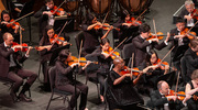 Violinists Dr. Feng and medical student Angela Wang (center row) perform at the Eisemann Center for Performing Arts in Richardson as members of World Doctors Orchestra. <em>Credit: Fernando Benitez, M.D.</em>