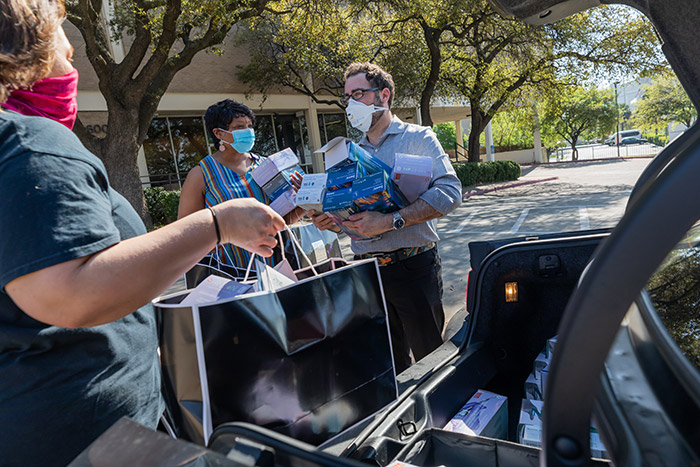 Dr. Glenn Krieger of Krieger Orthodontics dropped of donations of 5,000 boxes of gloves, 400 masks, and 45 boxes of Girl Scout cookies to the Central Receiving Office at UTSW’s Service Building (X) on March 26. People wearing masks picking up boxes of goods