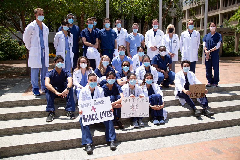 A group of cardiology fellows posed at the rally along with faculty mentors. The Department’s fellows helped organize the rally at Seldin Plaza. People in scrubs, white lab coats, wearing surgical masks, holding signs in support of black lives