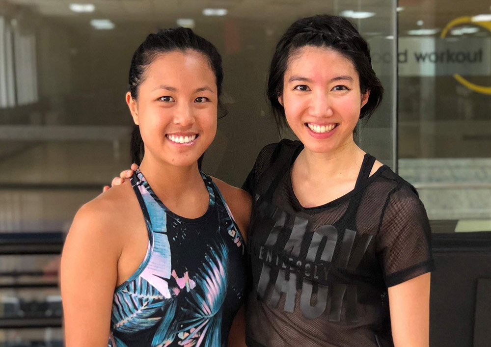 Hai-Uyen Nguyen (right) with her best friend Tracey Phan (left) after teaching her weekly Body Combat group fitness class. Two women in athletic wear smiling