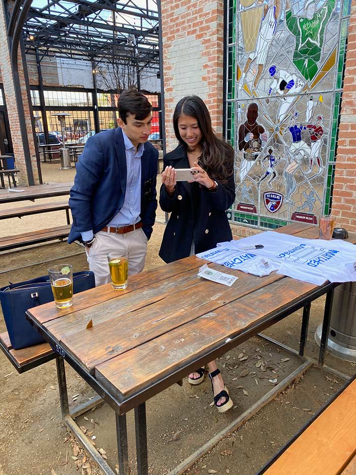 Mr. Gelvez and Ms. Tanamal learn of the residency matches in an email. Two people in courtyard reading a note together