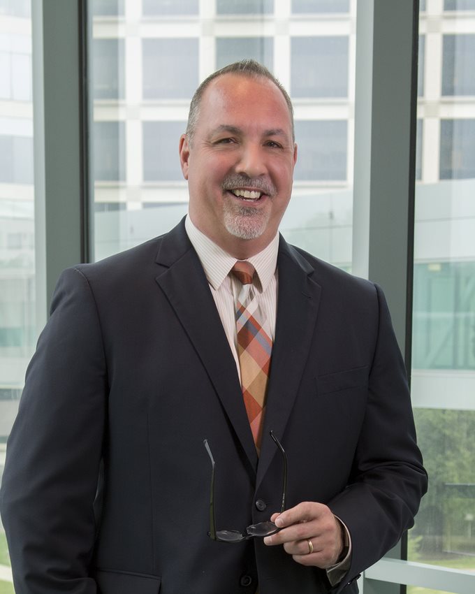 Dr. Sprague man in dark grey suit with plaid tie