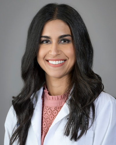 woman in pink sweater and white lab coat