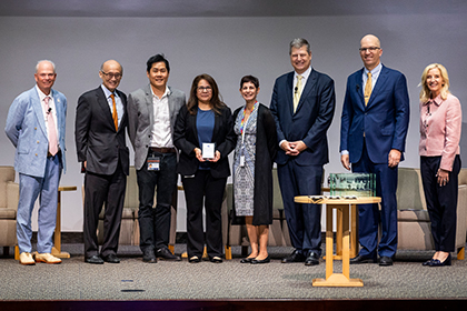 Seven people gather onstage with the poster winner.