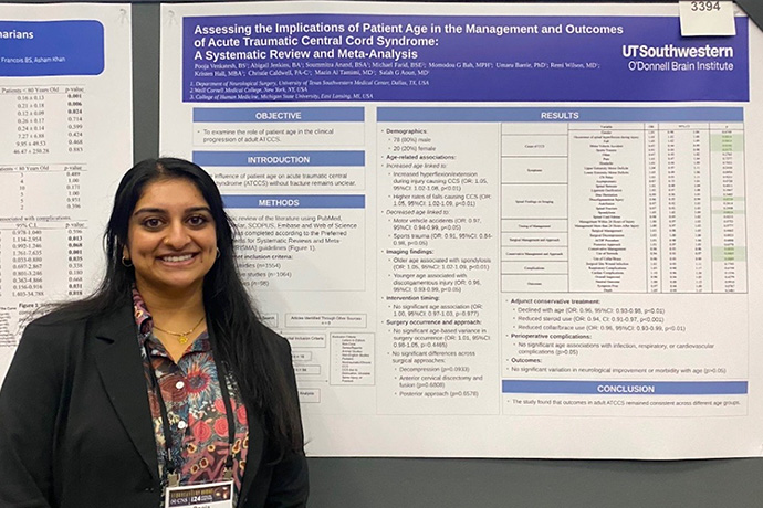 female med student with dark hair presents research findings on stage
