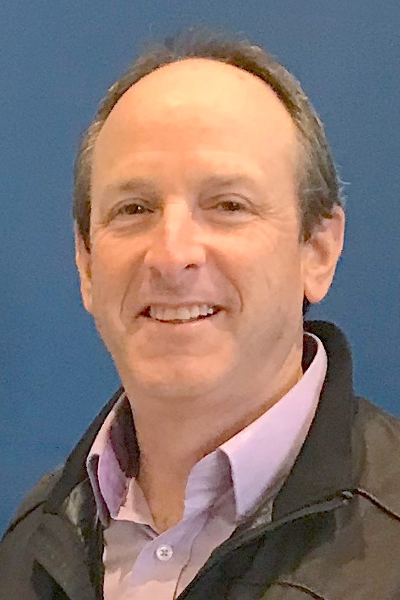 Rick Press headshot; white man with thinning brown hair wearing black jacket and pink shirt