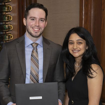 man holding diploma on left, woman smiling on right