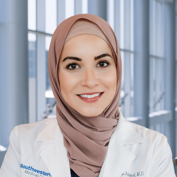Omaira Azizad, M.D., woman with brown hair, and medical coat, smiling