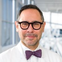 Siavosh Saatee, M.D., man with black glasses and bow tie, smiling