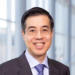 a man with glasses wearing a dark suit