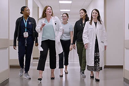 A group of hospital employees walking down a hallway.