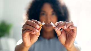 a woman breaking a ciggarette in half width=