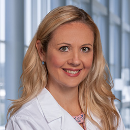 Dr. Brooks Brodrick wearing a white lab coat standing in the Clements University Hospital lobby
