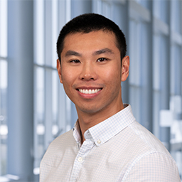 Michael Dang wearing a white shirt, standing in the Clements University Hospital lobby