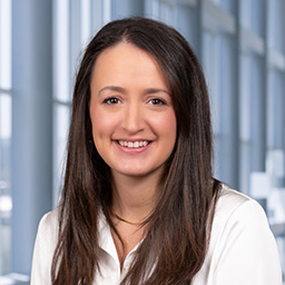 Autumn Noon wearing a white shirt and standing in the Clements University Hospital lobby