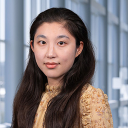 Yixin Tang wearing a yellow shirt, standing in the Clements University Hospital lobby