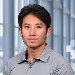 Michael Wu wearing a grey shirt, standing in the Clements University Hospital lobby