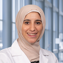 Dr. Sarah Zamamiri wearing a tan head scarf and white lab coat