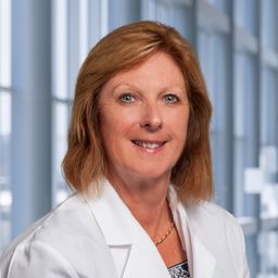 Dr. Lynda Bennett wearing a white lab coat standing in the Clements University Hospital lobby