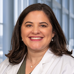 Dr. Vivian Irizarry Gatell wearing a white lab coat standing in the Clements University Hospital lobby