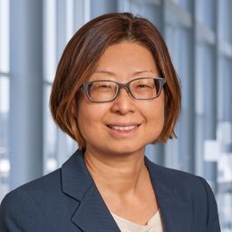 Dr. Hattie Jeon-Slaugheter wearing glasses and blue jacket in the Clements University Hospital lobby