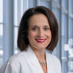 Dr. Dawn Klemow-Reed wearing a white lab coat standing in the Clements University Hospital lobby