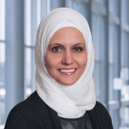 Dr. Sawsan Rashdan wearing a black jacket and a white hajib standing in the Clements University Hospital lobby