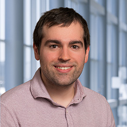 Dr. Pano Theodoropoulos wearing a red patterned shirt standing in the Clements University Hospital lobby