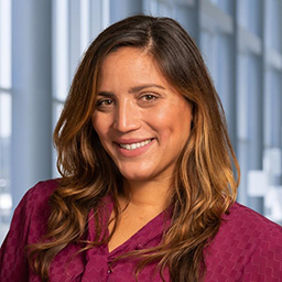 Dr. Cristina Marce-Lazo wearing a maroon patterend shirt, standing in the Clements University Hospital lobby