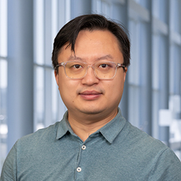 a man wearing glasses and a grey shirt